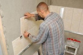 Процесс укладки плитки на стену